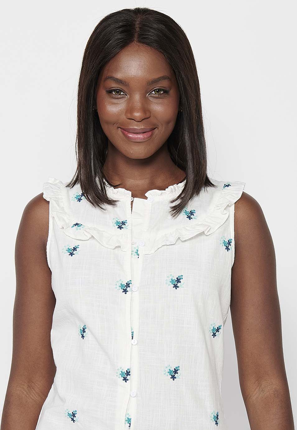 Blusa sin mangas de algodón de mini volante en los hombros con tela con bordados florales y cuello redondo y cierre delantero con botones elásticos para mujer | moda actual