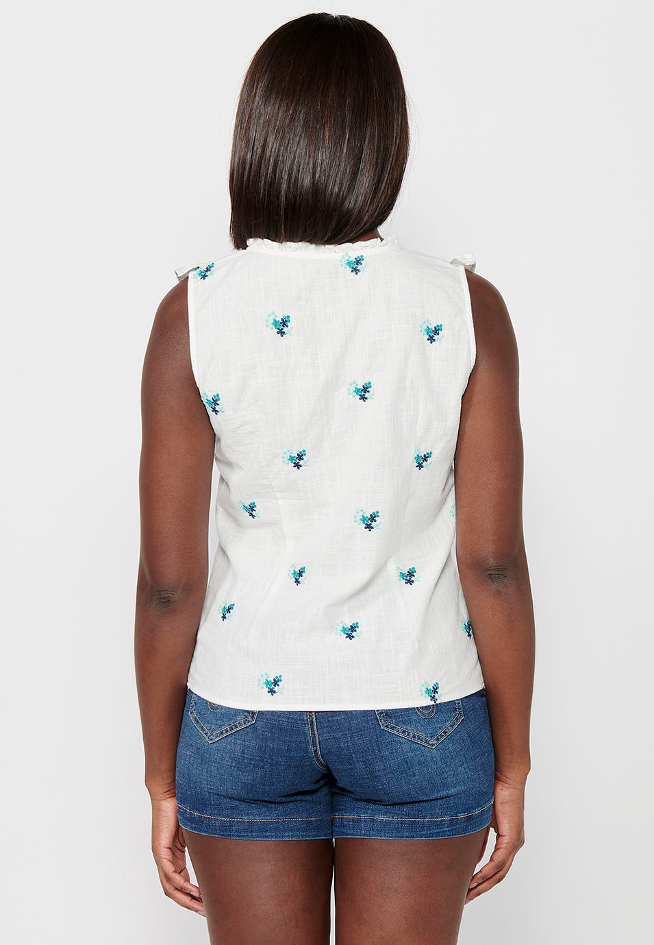 Blusa sin mangas de algodón de mini volante en los hombros con tela con bordados florales y cuello redondo y cierre delantero con botones elásticos para mujer | moda actual