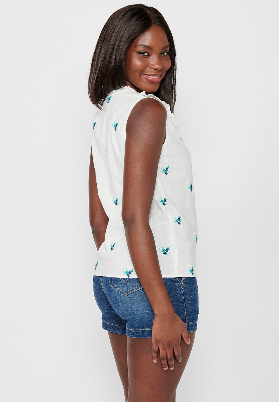 Blusa sin mangas de algodón de mini volante en los hombros con tela con bordados florales y cuello redondo y cierre delantero con botones elásticos para mujer | moda actual