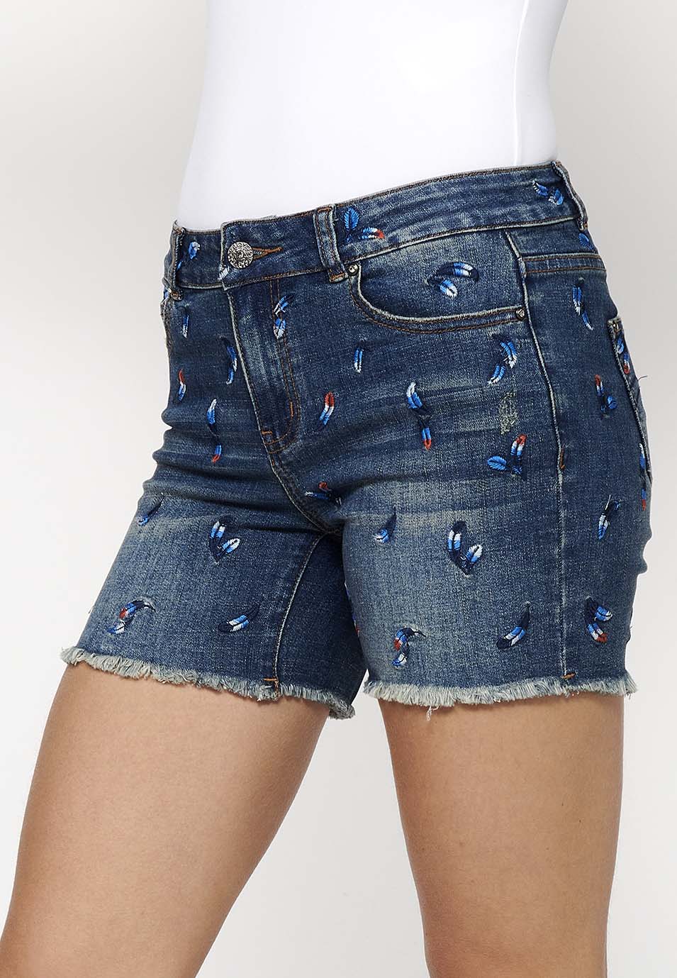 Pantalón corto denim con cierre delantero con cremallera y botón y tela con bordados con cinco bolsillos, uno cerillero para mujer | moda actual