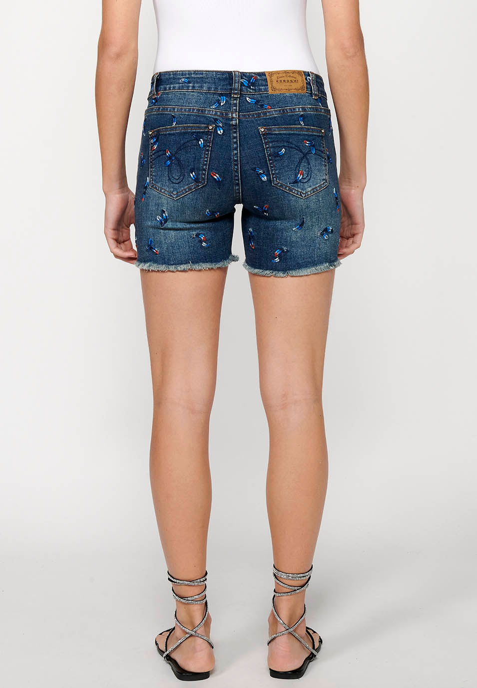 Pantalón corto denim con cierre delantero con cremallera y botón y tela con bordados con cinco bolsillos, uno cerillero para mujer | moda actual