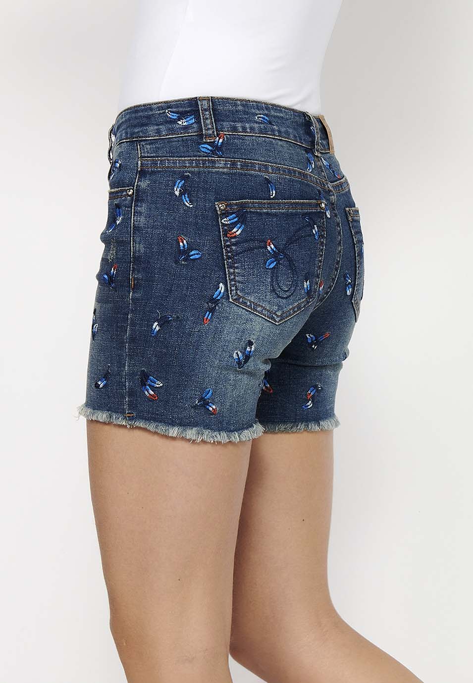 Pantalón corto denim con cierre delantero con cremallera y botón y tela con bordados con cinco bolsillos, uno cerillero para mujer | moda actual