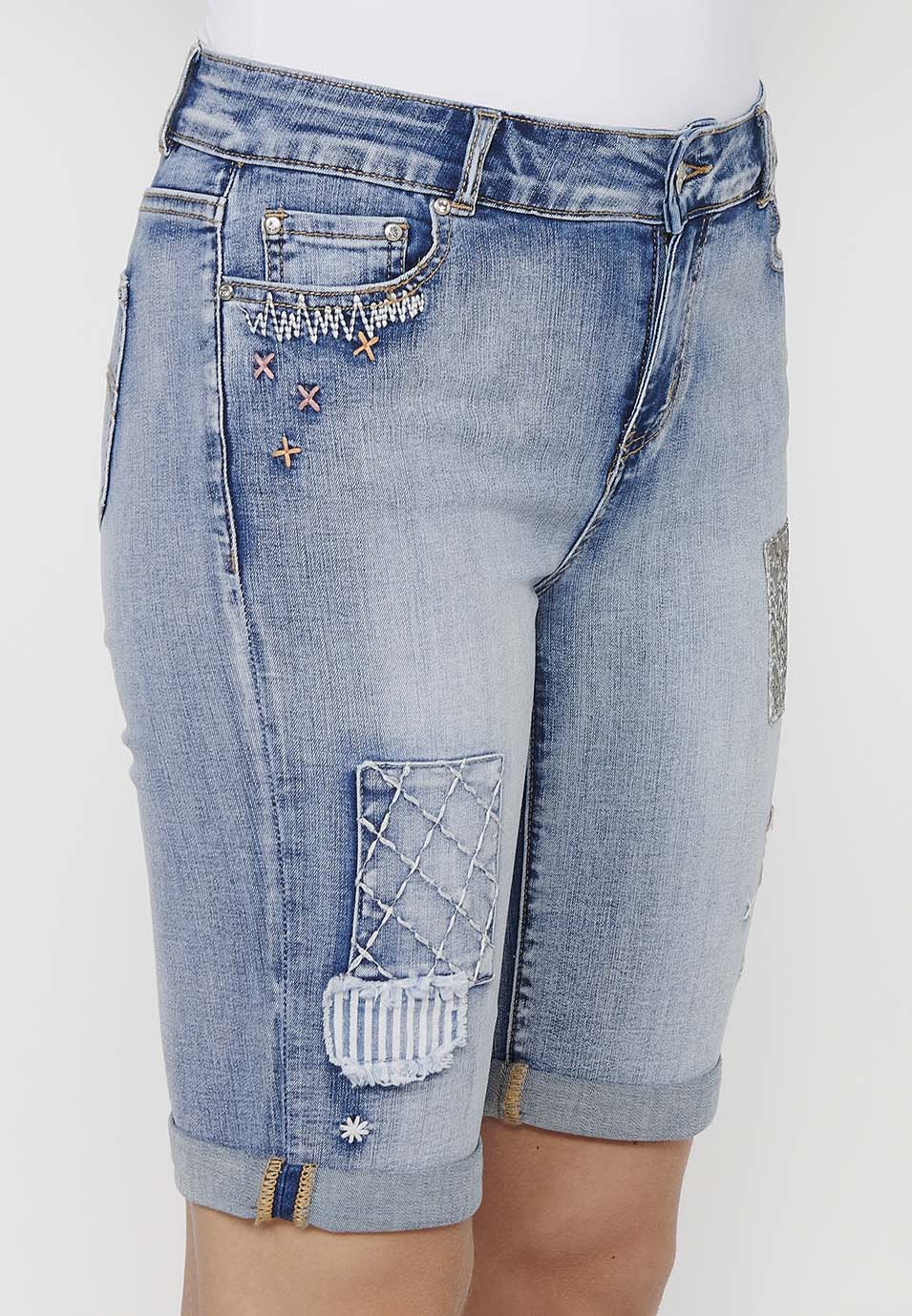 Pantalón corto short acabado en vuelta con detalles de parches delanteros y cadena adorno extraíble con cierre delantero con cremallera y botón para mujer | moda actual