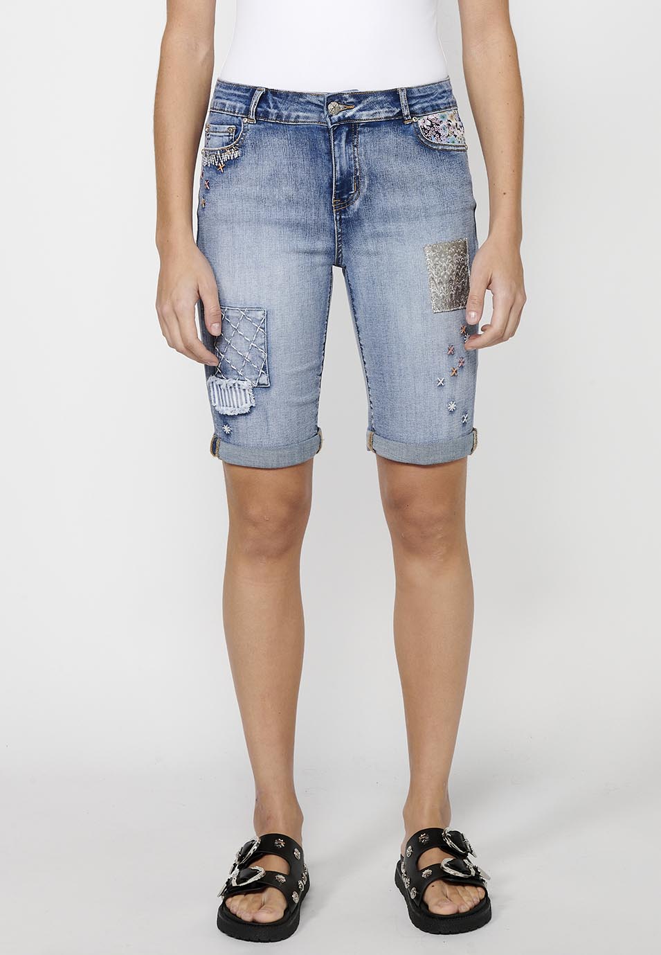 Pantalón corto short acabado en vuelta con detalles de parches delanteros y cadena adorno extraíble con cierre delantero con cremallera y botón para mujer | moda actual