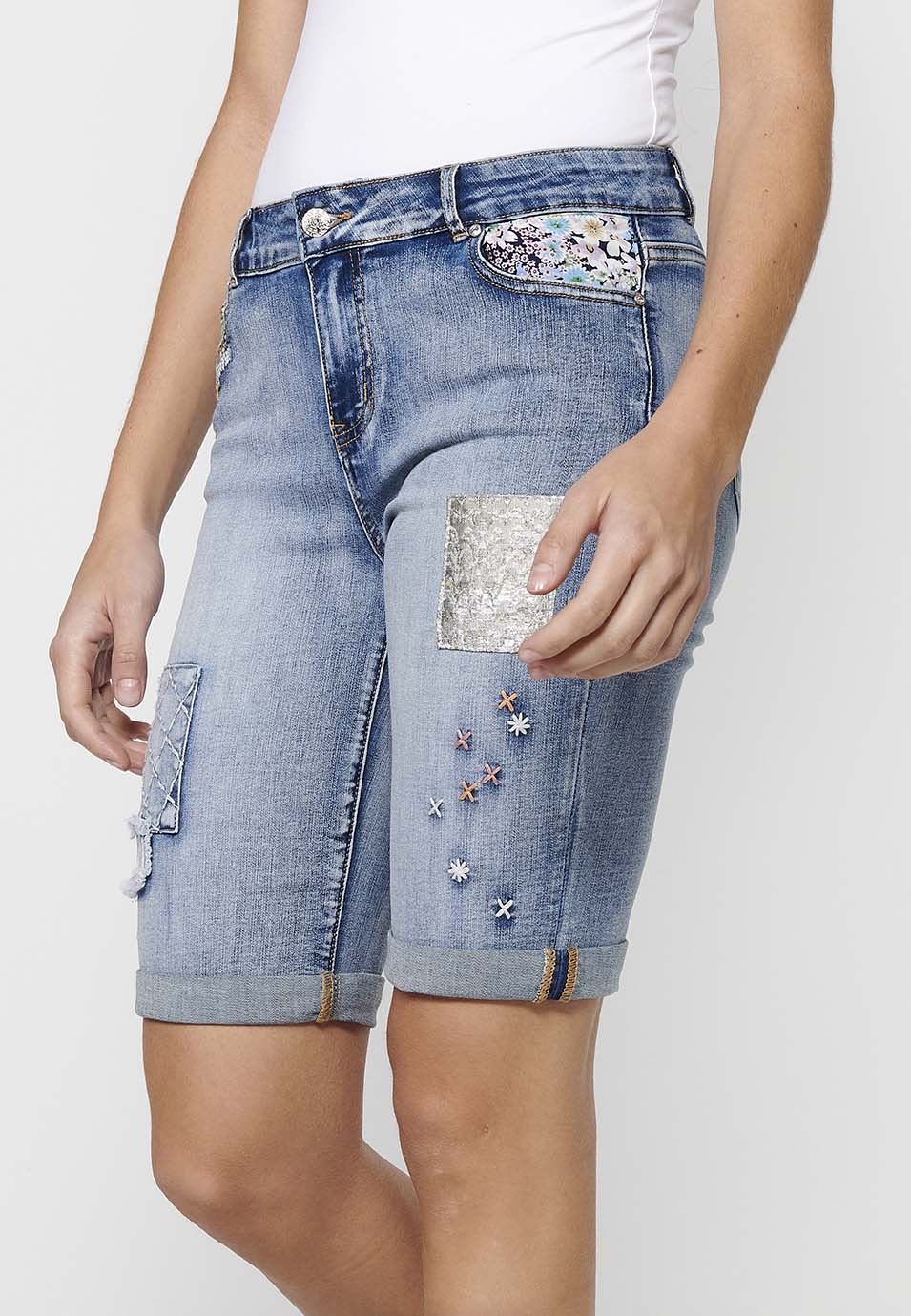 Pantalón corto short acabado en vuelta con detalles de parches delanteros y cadena adorno extraíble con cierre delantero con cremallera y botón para mujer | moda actual