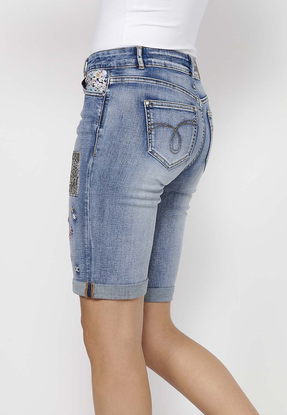 Pantalón corto short acabado en vuelta con detalles de parches delanteros y cadena adorno extraíble con cierre delantero con cremallera y botón para mujer | moda actual