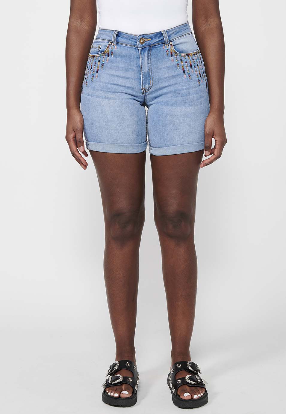 Pantalón corto short acabado en vuelta con cierre delantero con cremallera y botón con detalles bordados para mujer | moda actual