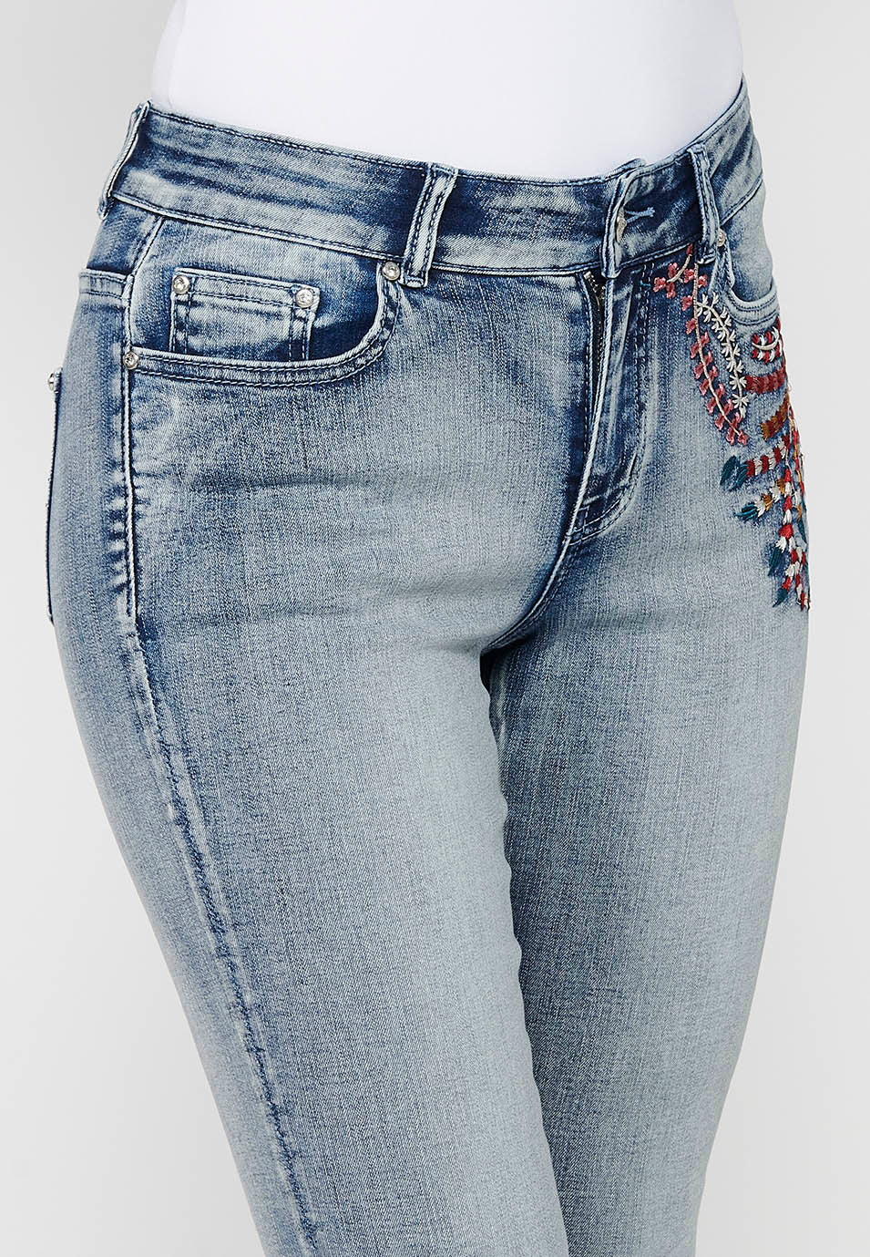 Pantalón largo denim con detalles bordados y cierre delantero con cremallera y botón de claro para mujer | moda actual
