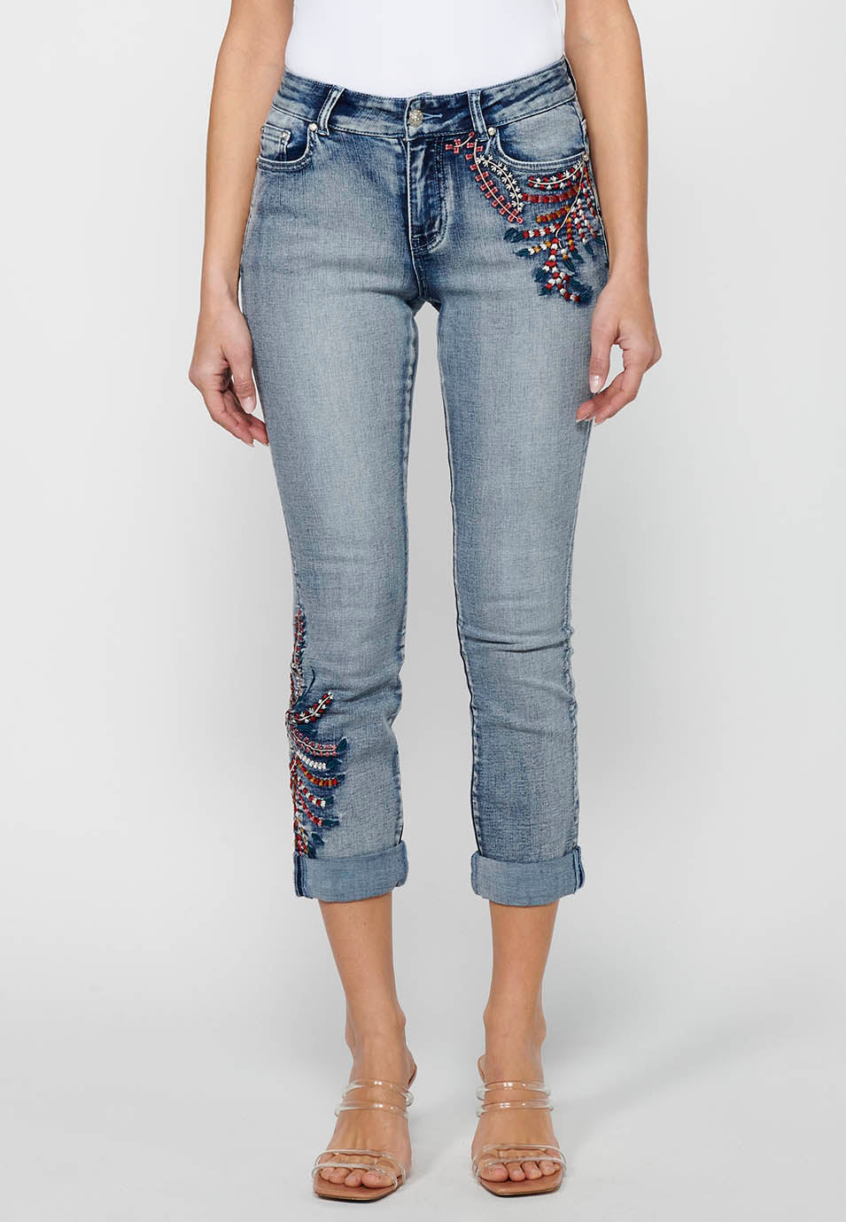 Pantalón largo denim con detalles bordados y cierre delantero con cremallera y botón de claro para mujer | moda actual