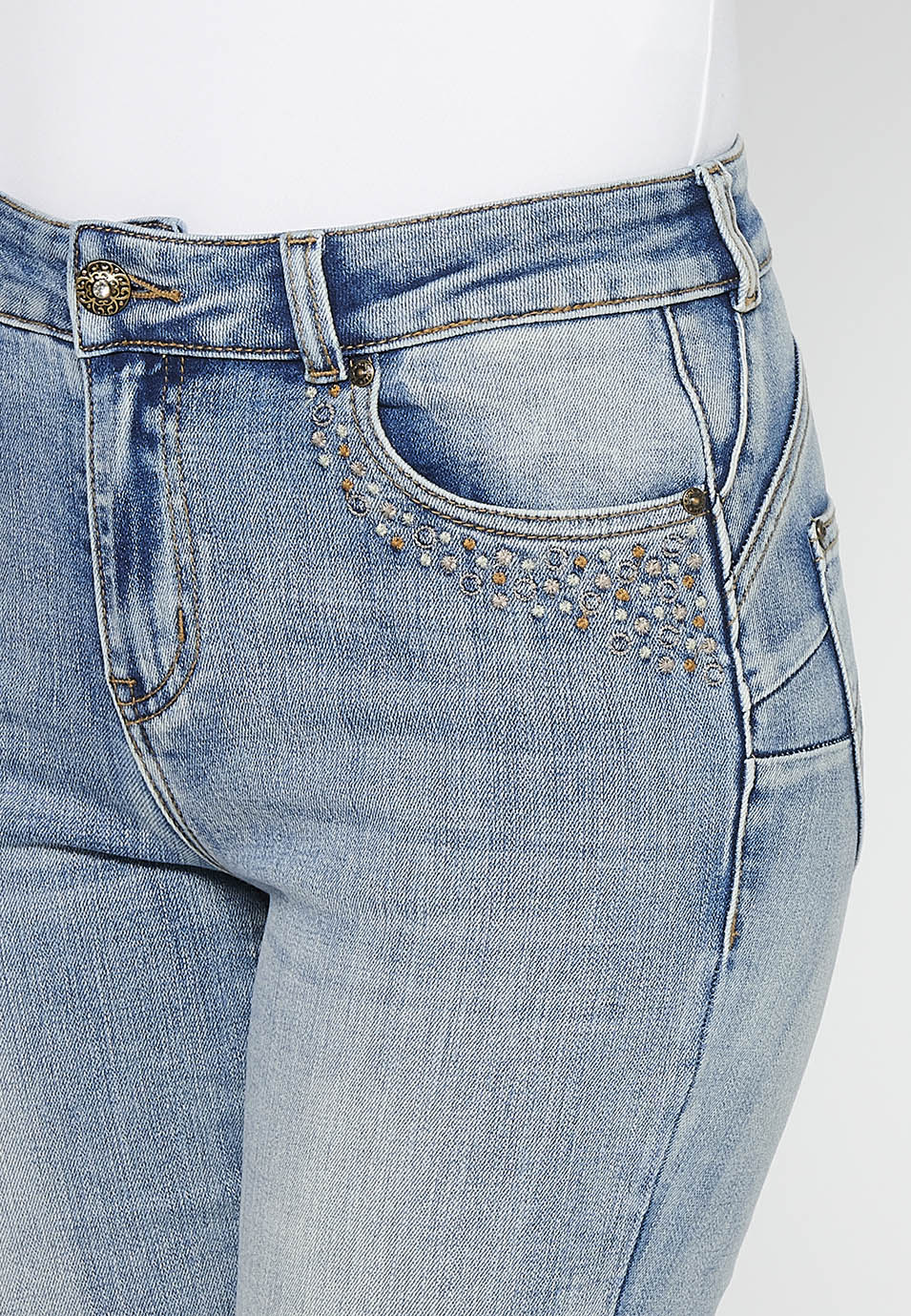 Pantalón largo acabado en campana con cierre delantero con cremallera y botón con detalles de rotos de claro para mujer | moda actual