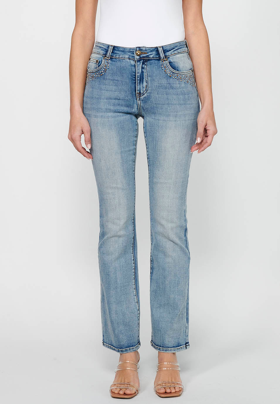 Pantalón largo acabado en campana con cierre delantero con cremallera y botón con detalles de rotos de claro para mujer | moda actual