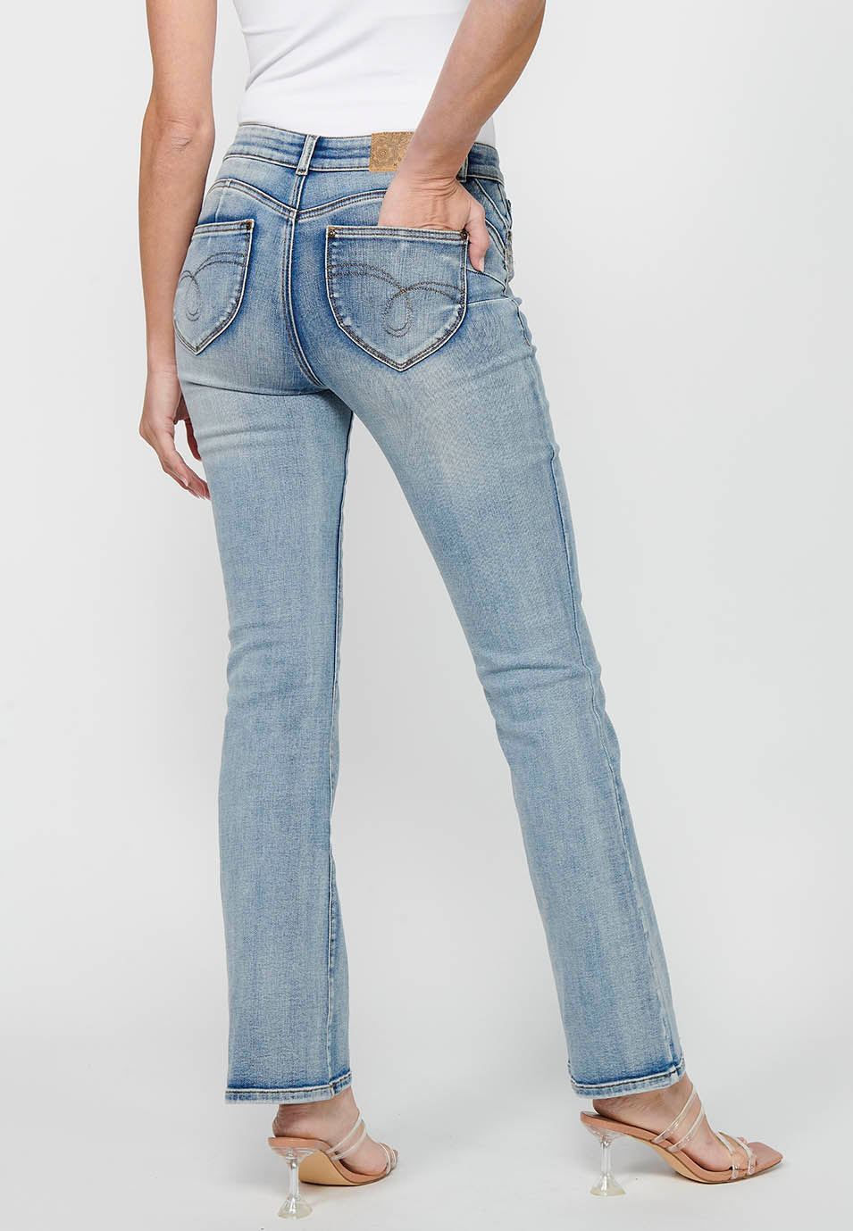 Pantalón largo acabado en campana con cierre delantero con cremallera y botón con detalles de rotos de claro para mujer | moda actual