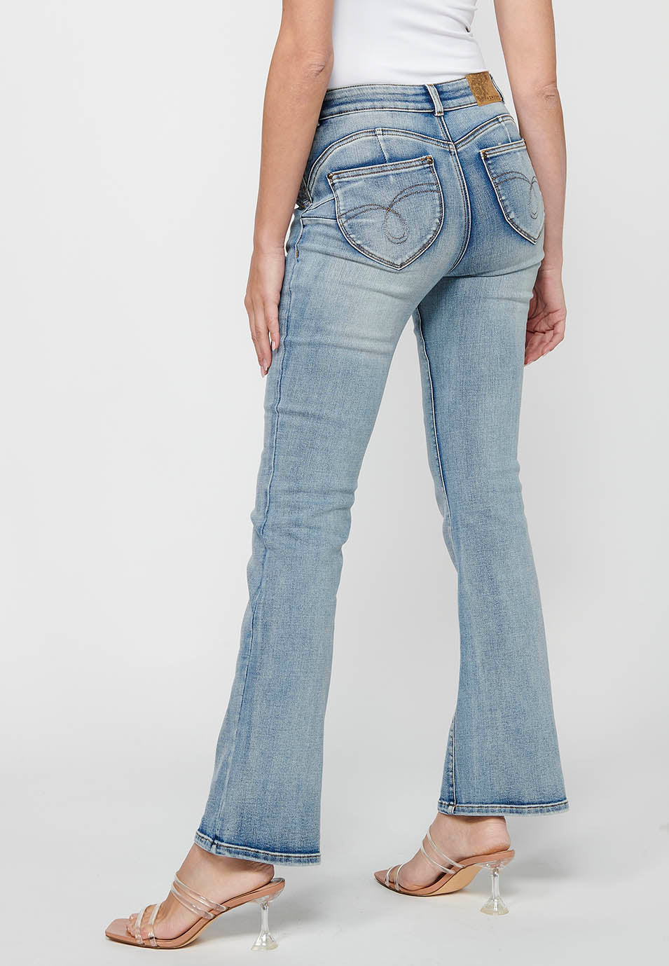 Pantalón largo acabado en campana con cierre delantero con cremallera y botón con detalles de rotos de claro para mujer | moda actual