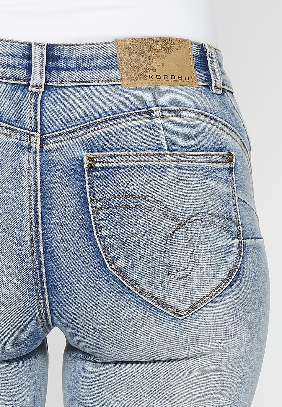 Pantalón largo acabado en campana con cierre delantero con cremallera y botón con detalles de rotos de claro para mujer | moda actual