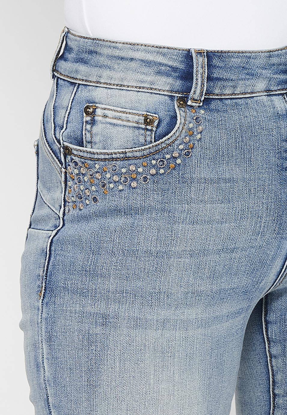 Pantalón largo acabado en campana con cierre delantero con cremallera y botón con detalles de rotos de claro para mujer | moda actual