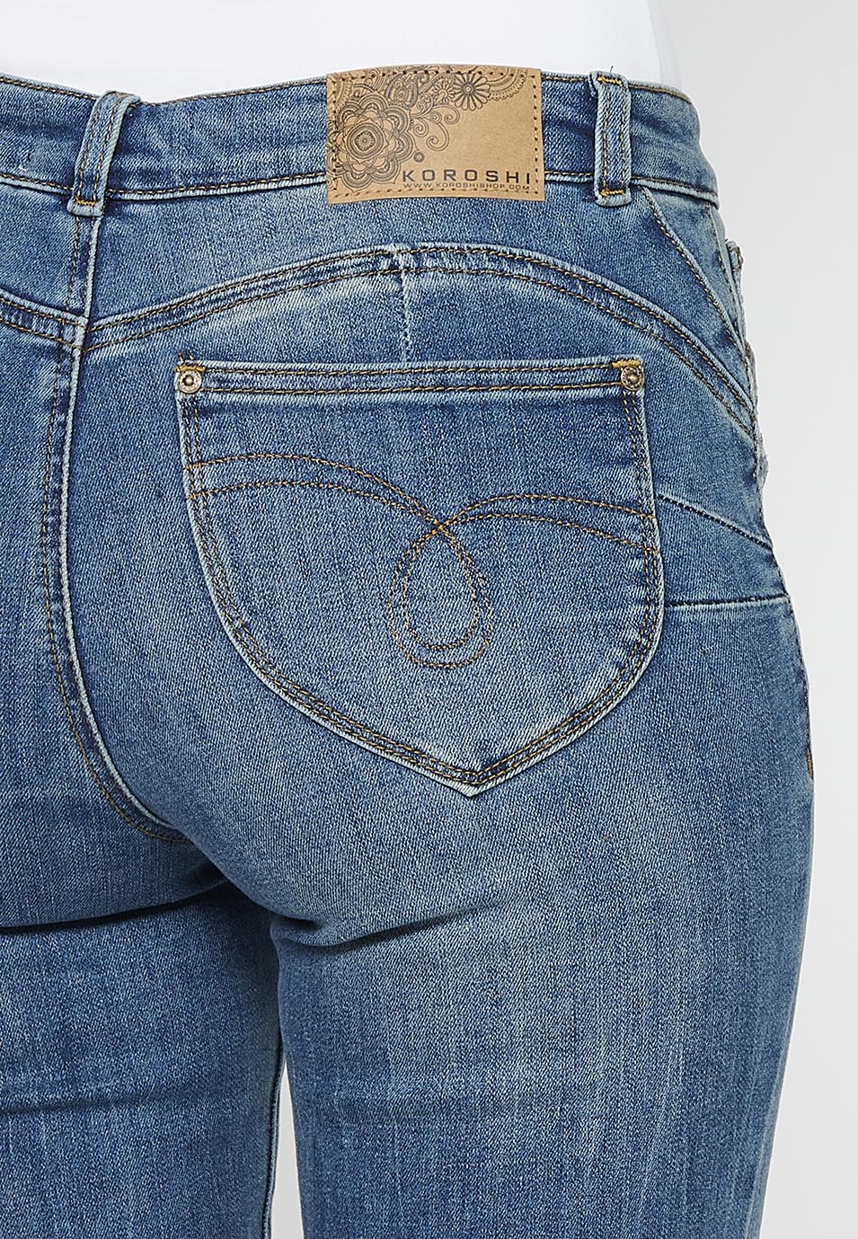 Pantalón largo acabado en campana con cierre delantero con cremallera y botón con detalles de rotos de claro para mujer | moda actual