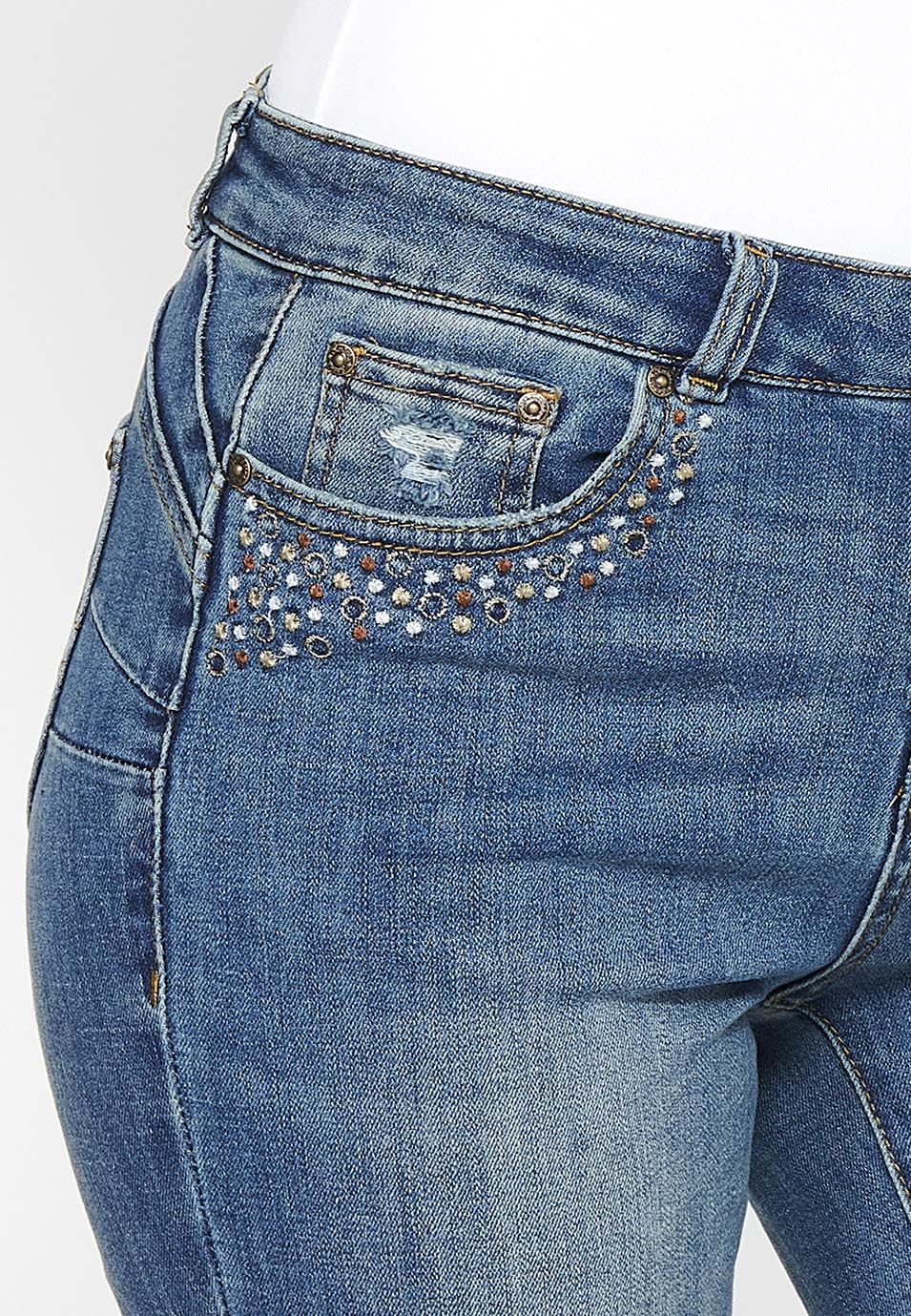 Pantalón largo acabado en campana con cierre delantero con cremallera y botón con detalles de rotos de claro para mujer | moda actual
