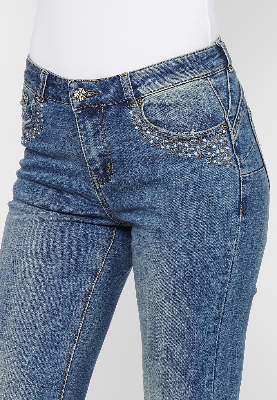 Pantalón largo acabado en campana con cierre delantero con cremallera y botón con detalles de rotos de claro para mujer | moda actual