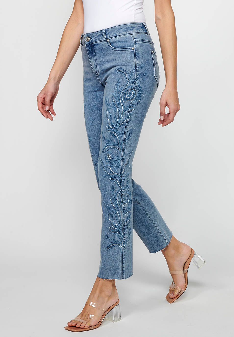 Pantalón denim largo campana con cierre delantero con cremallera y detalles bordados florales de claro para mujer | moda actual
