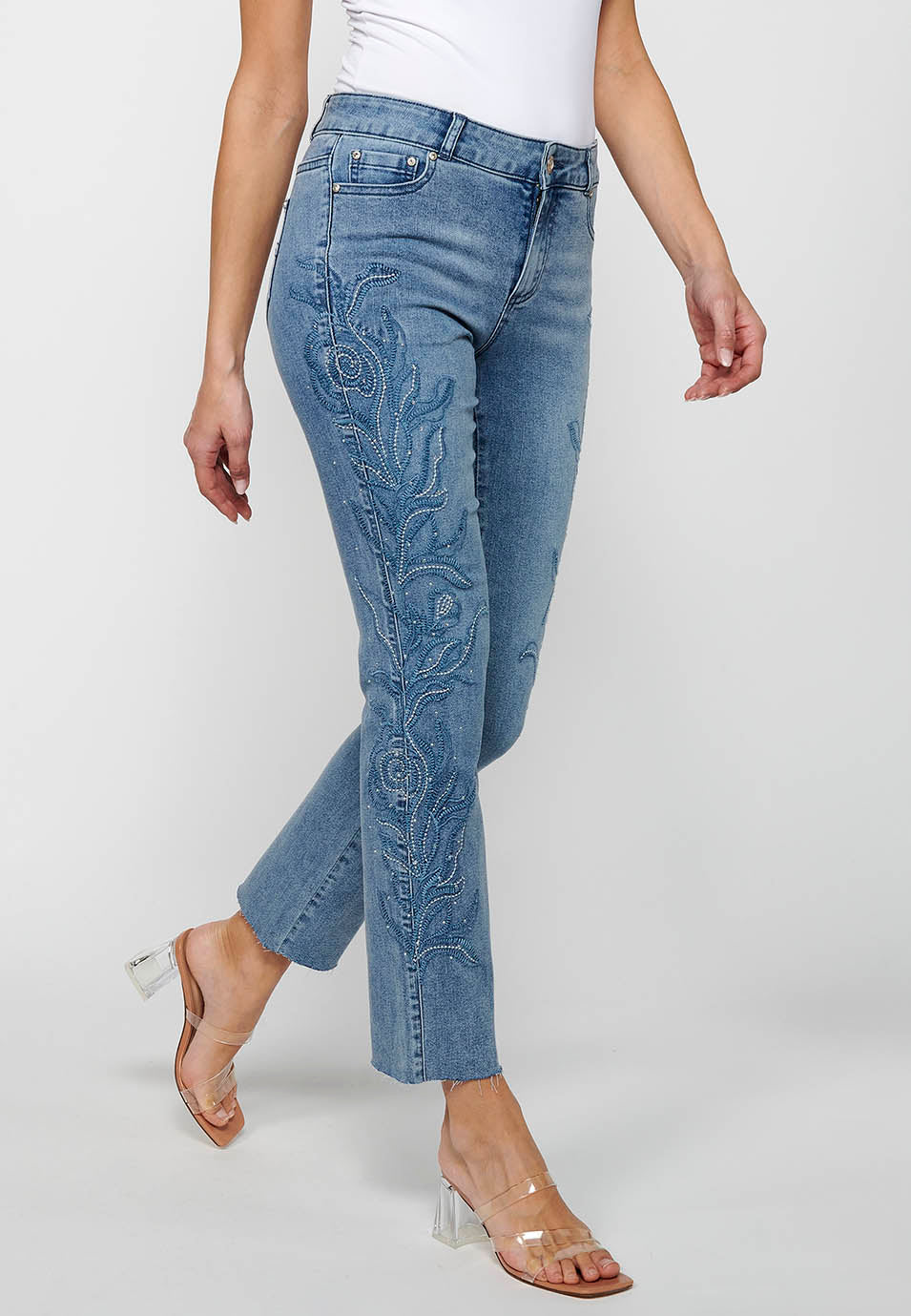 Pantalón denim largo campana con cierre delantero con cremallera y detalles bordados florales de claro para mujer | moda actual