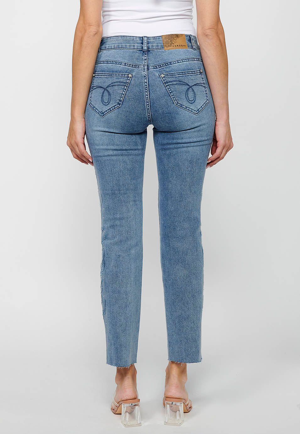 Pantalón denim largo campana con cierre delantero con cremallera y detalles bordados florales de claro para mujer | moda actual