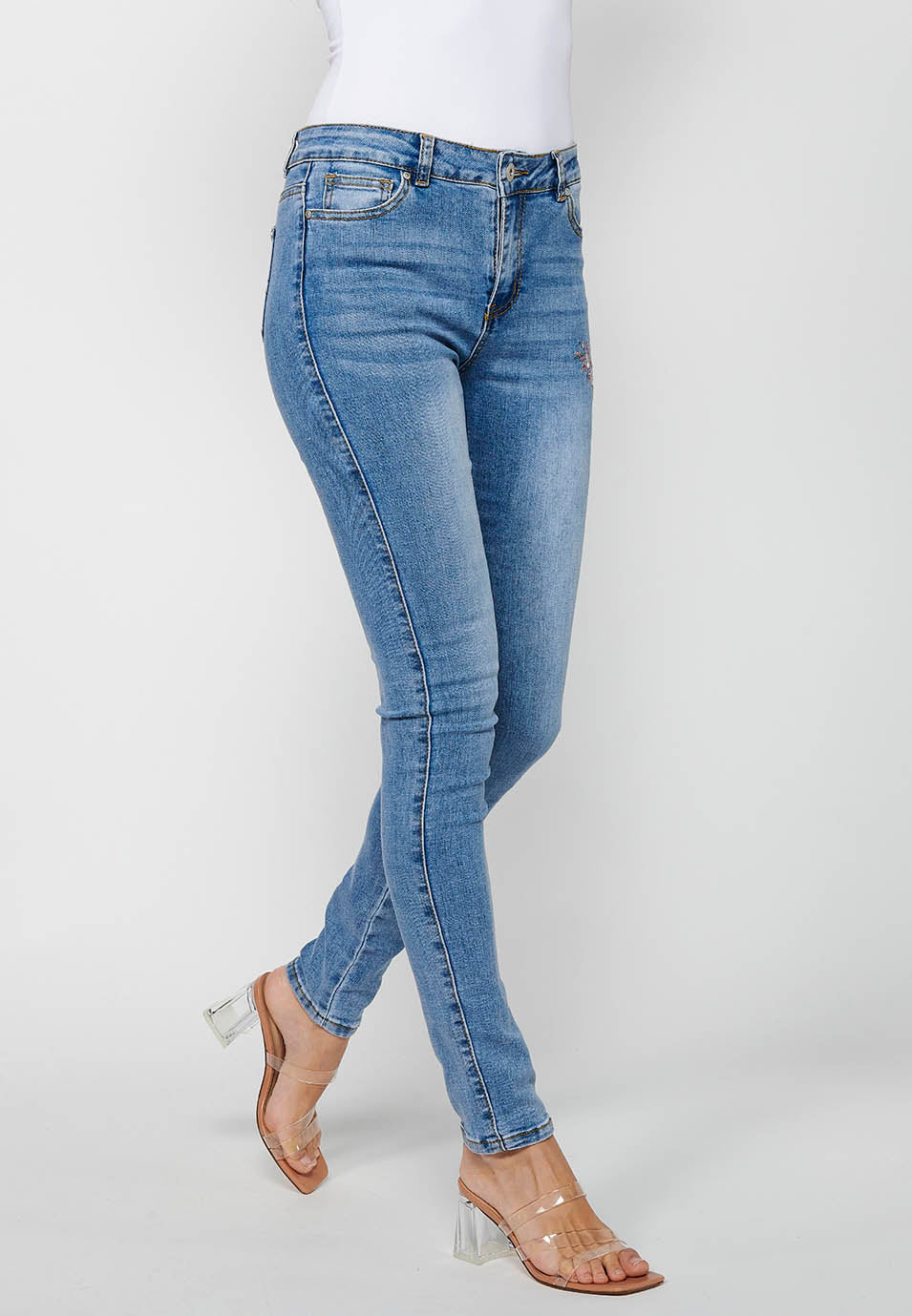 Pantalón largo slim con cierre delantero con cremallera y botón con detalles bordados para mujer | moda actual