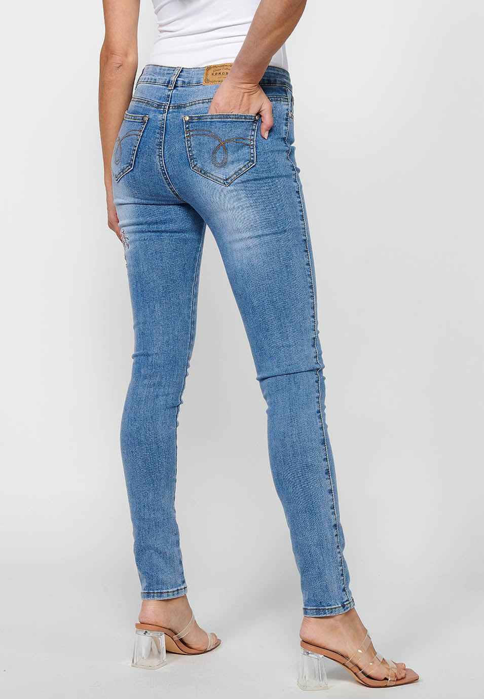 Pantalón largo slim con cierre delantero con cremallera y botón con detalles bordados para mujer | moda actual
