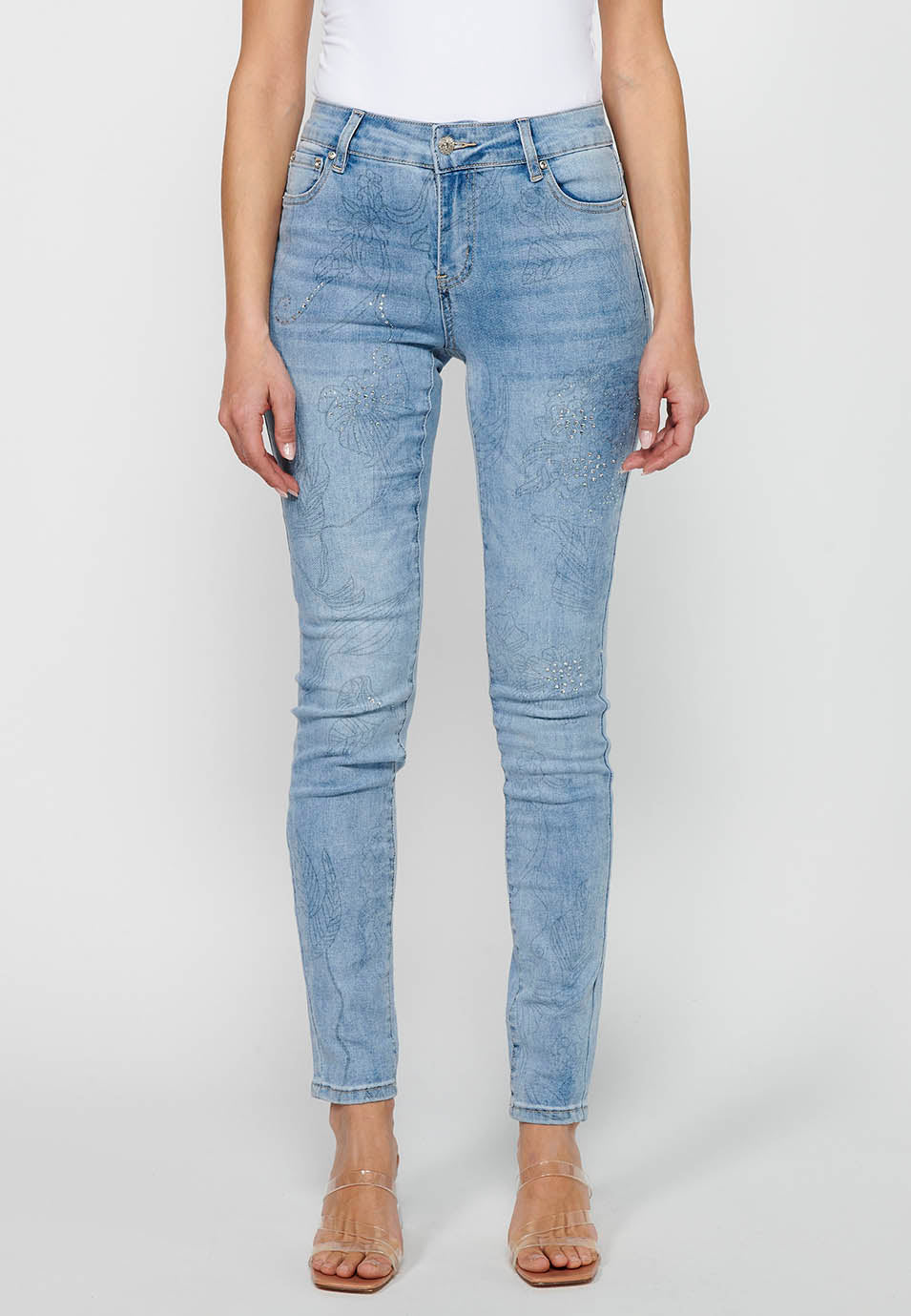 Pantalón largo denim slim con detalles florales y cierre delantero con cremallera y botón de claro para mujer | moda actual