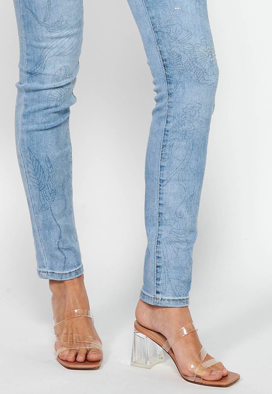 Pantalón largo denim slim con detalles florales y cierre delantero con cremallera y botón de claro para mujer | moda actual