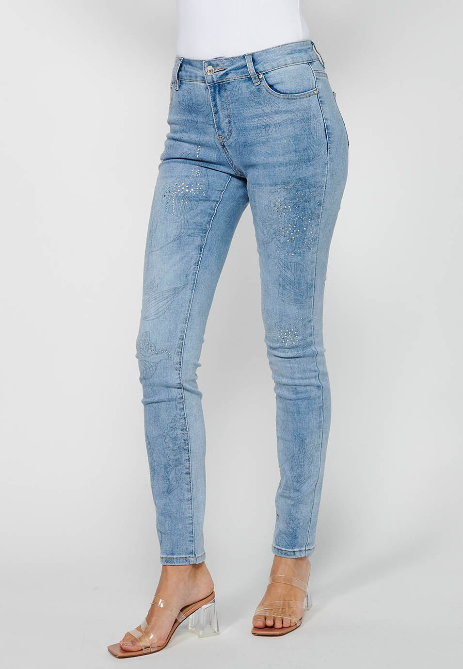 Pantalón largo denim slim con detalles florales y cierre delantero con cremallera y botón de claro para mujer | moda actual