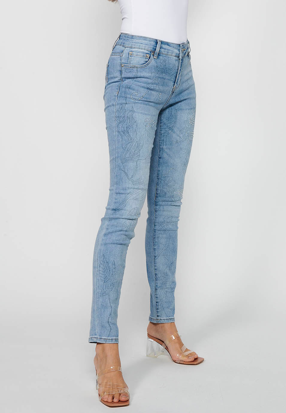 Pantalón largo denim slim con detalles florales y cierre delantero con cremallera y botón de claro para mujer | moda actual