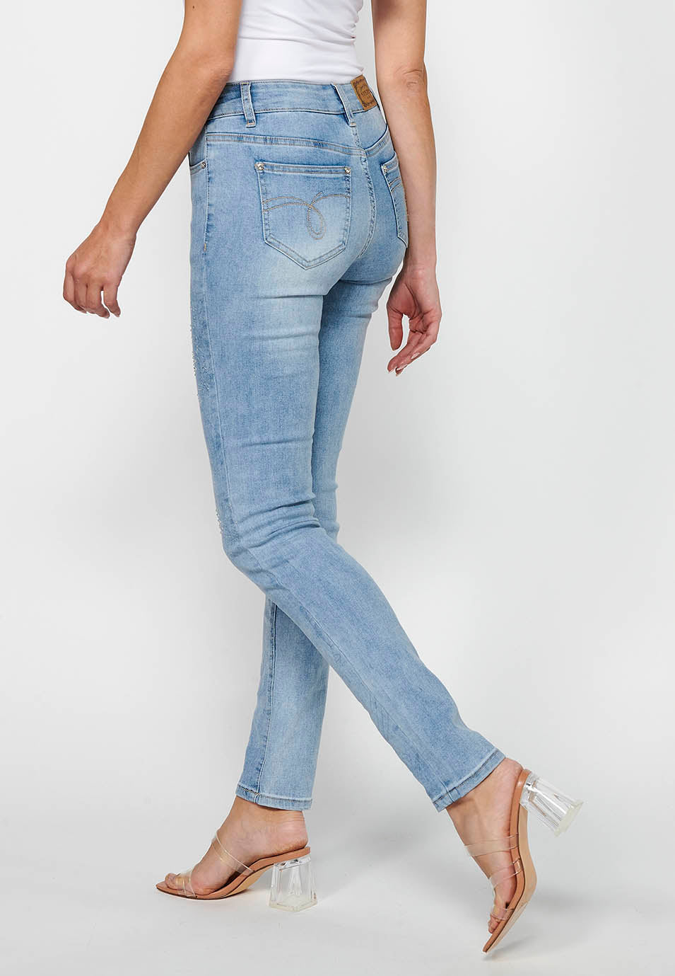 Pantalón largo denim slim con detalles florales y cierre delantero con cremallera y botón de claro para mujer | moda actual