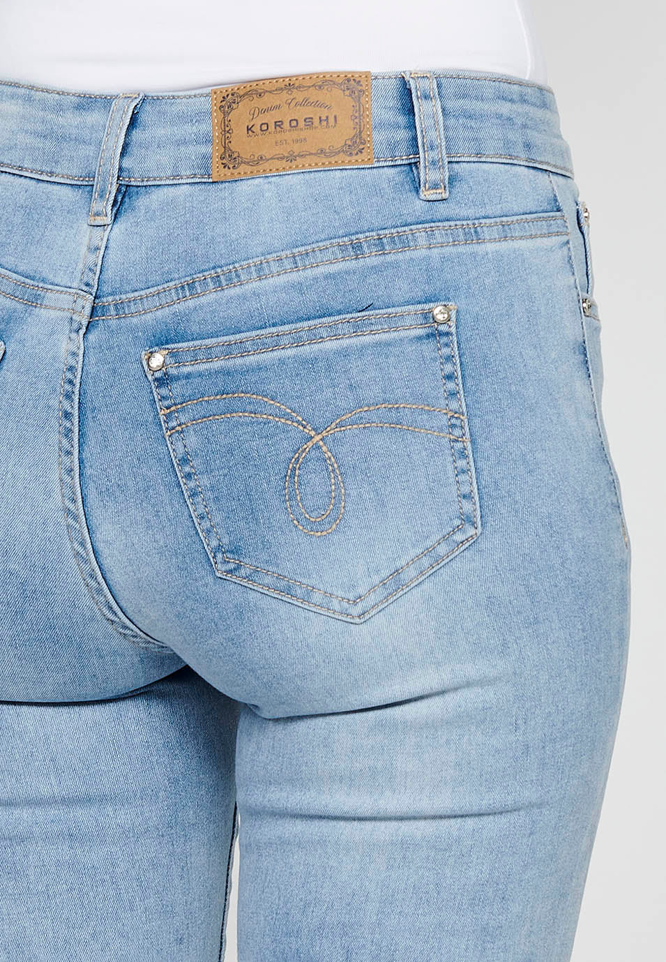 Pantalón largo denim slim con detalles florales y cierre delantero con cremallera y botón de claro para mujer | moda actual