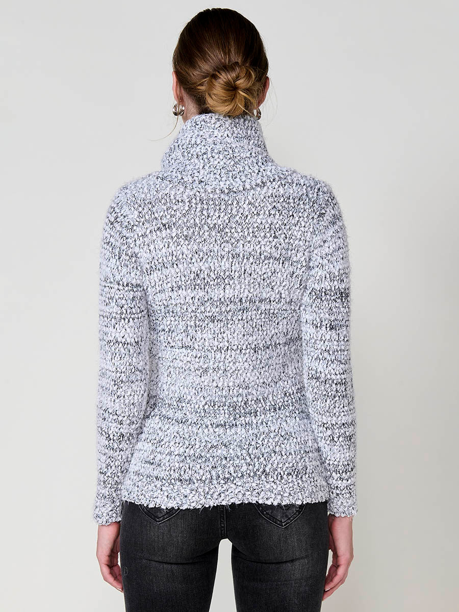 Jersey de mujer con pelo de tacto suave, cuello alto, textura bicolor en hilo chenilla y placa metálica koröshi.
