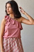 Top asimétrico volante color rosa maquillaje