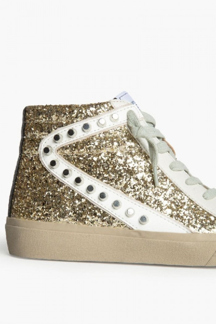 Sneakers dorada con detalle blanco, glitter y tachuelas